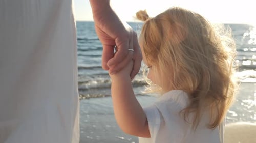 Child Holding Hand Walking on Beautiful Sunny Beach