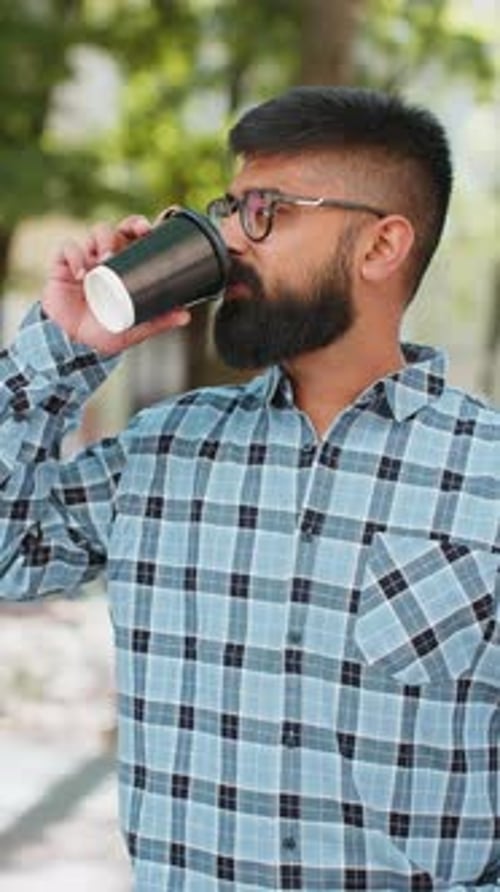 Happy Indian Man Enjoying Drinking Morning Coffee Hot Drink Relaxing Taking a Break on City Street