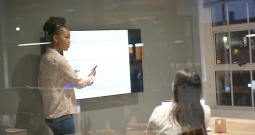 Young African American woman presents in a modern office setting