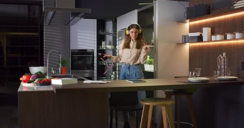 Cheerful Woman Dancing and Singing in Kitchen
