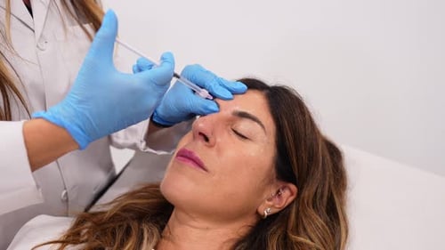 Woman Receiving Cosmetic Injection in Forehead at Clinic