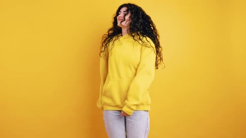 Smiling Woman Dancing with a Yellow Background