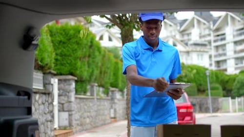 Smiling Delivery Worker Signs Clipboard on Street