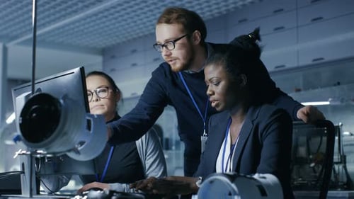 Team of Colleagues Working Together on Computer
