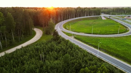 Breathtaking Aerial View of a Forest Road and Highway at Sunset Capturing Natures Tranquility and
