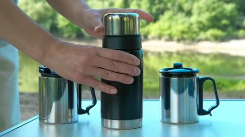 Pouring Tea From Thermos During Picnic
