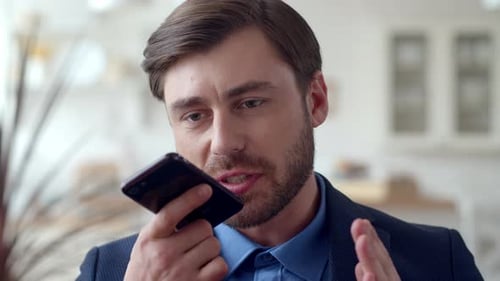 Serious man talking into cellphone in office