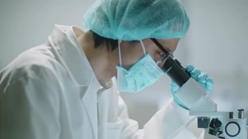 Scientist Looks Through Microscope in Modern Lab