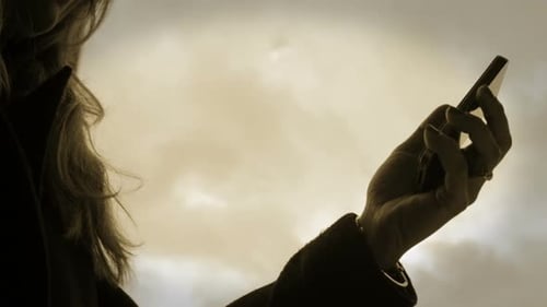 Arm Holding a Mobile Phone to the Sky