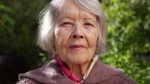 Closeup of the Face of an Old Grandmother with Gray Hair in the Park