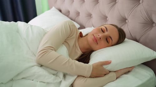Woman Peacefully Sleeping in a Comfortable Bed
