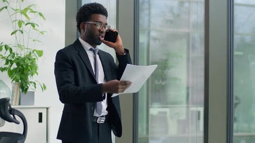 Professional Man Talking on Cellphone in Modern Office