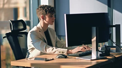Young man is working in a computer in an office