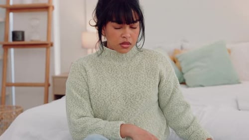 Anxious Woman With Phone Sitting on Bed