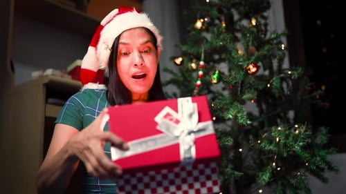 Woman Opens Christmas Present Near Christmas Tree