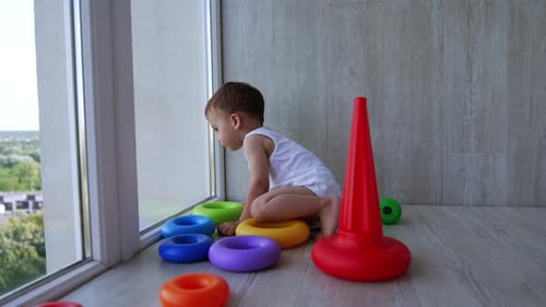 Young Child Playing with Colorful Stacking Rings