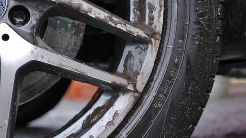 Closeup da roda de carro suja com bolhas de sabão - Car Wash Concept.