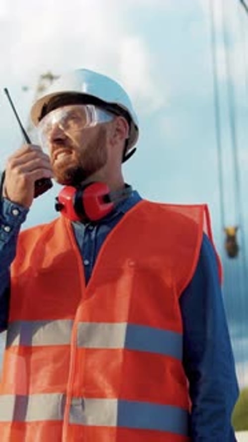 Construction Worker Talking Into Walkie Talkie at Workplace