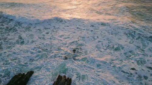 Foaming Waves Splashing Coastal Stones Closeup Ocean Surface Reflecting Sunset