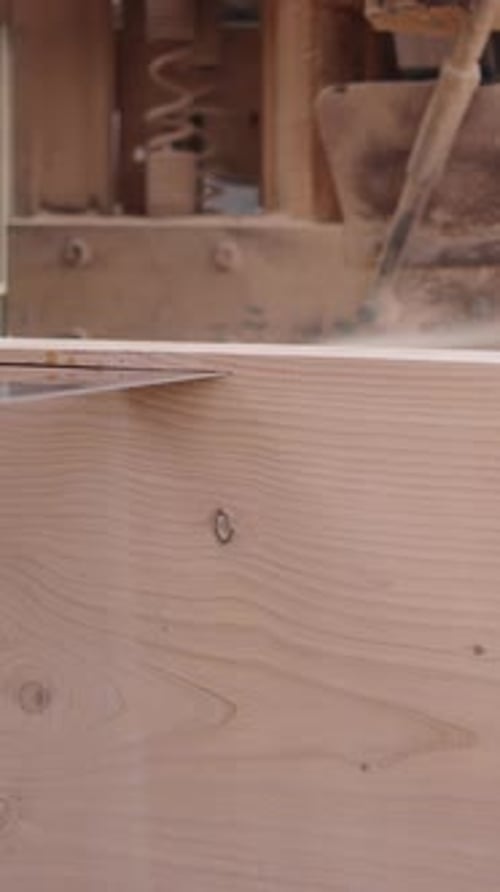 A Wood Cutter Cutting a Piece of Wood