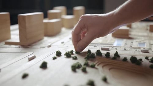Hand Placing Tree on Miniature City Model