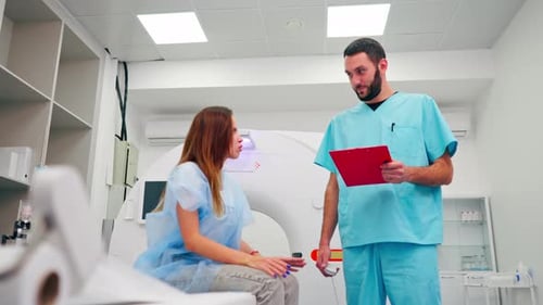 Doctor Consults with Patient Near Medical Scanning Machine