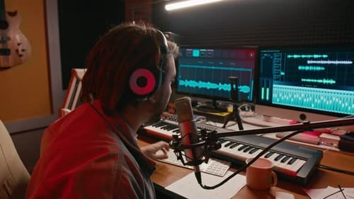 Caucasian Male Music Podcast Presenter Speaking into Microphone in Studio