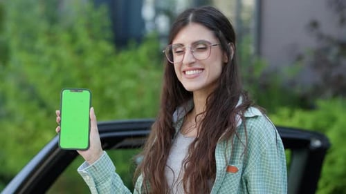Woman Showing Cell Phone with Green Screen Outside Female Holding Chroma Key Smartphone
