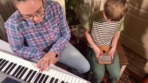 Woman and Child Playing Piano and Kalimba Together