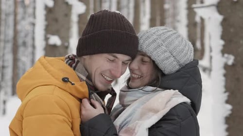 Affectionate Couple Snuggling in Snowy Forest Setting
