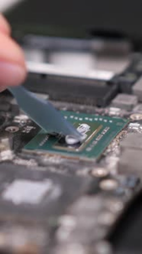 Vertical Video Closeup Applying Thermal Paste to Computer Processor Chip