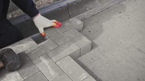 Construction Worker Laying Paving Stones in Herringbone Pattern