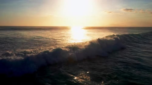 Aerial View Of Big Blue Ocean Wave Crashing With White Foam At Sunset Time