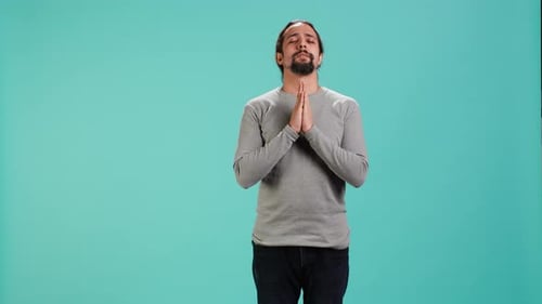 Man with Hands Clasped Against Blue Background
