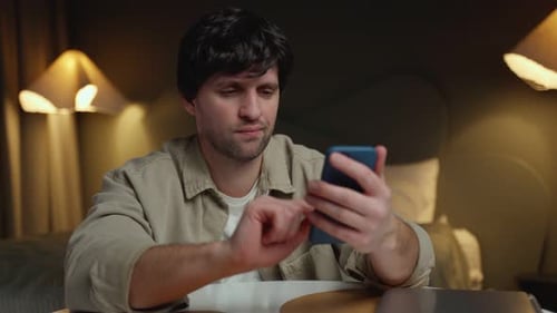 Man Using Mobile Phone Indoors at Night