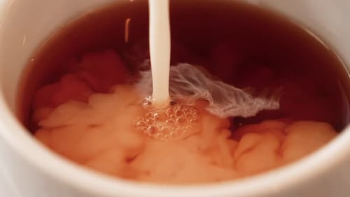 Milk Pouring into Cup of Tea Close Up