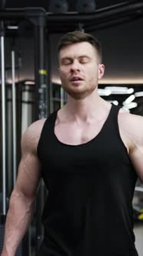 Muscular Man Walking Through a Gym