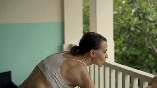 Young Woman Exercising, Stretching Body on Terrace 30s