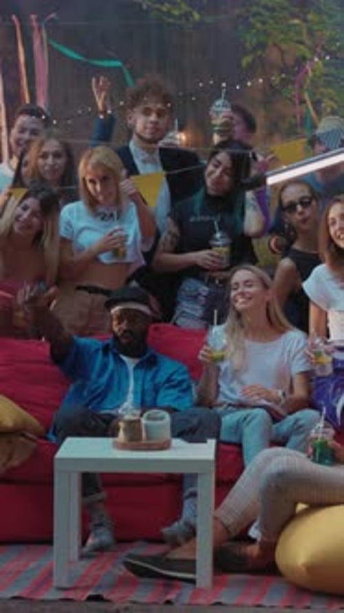 Enthusiastic Group Waving at Viewing Screen Outdoors