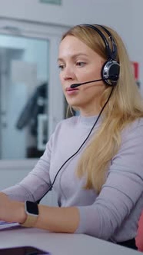 Focused Blonde Call Center Operator Wearing Headset and Smartwatch Providing Professional Remote