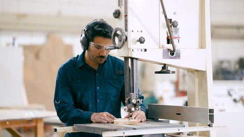 Professional Carpenter Cutting Wood with Bandsaw