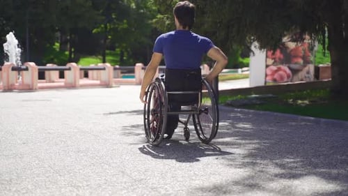 Young Adult Rolling in Wheelchair in Sunny Park