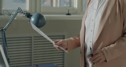 Professional Reads Documents in Bright Modern Office