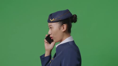 Nahaufnahme einer Flugbegleiterin, die auf dem grünen Bildschirm auf dem Smartphone spricht, während sie auf dem grünen Bildschirm läuft
