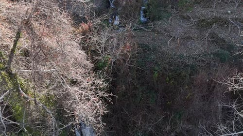 Aerial pouring of waterfall water, drone view, flow of water in greenery