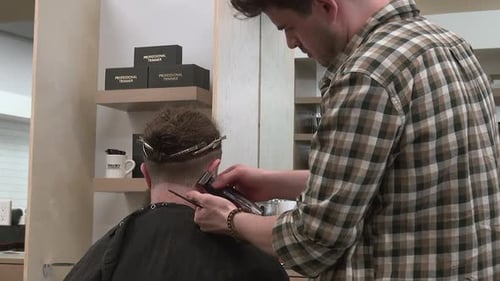 Man Trimming Hair with Professional Trimmer in Barbershop