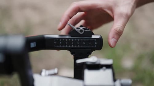 Hand Adjusts Video Rig Lever Outdoors