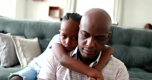Close Up of a Loving Father and Daughter Embracing on a Sofa