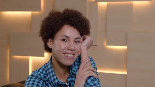 Smiling young woman looking at the camera indoors