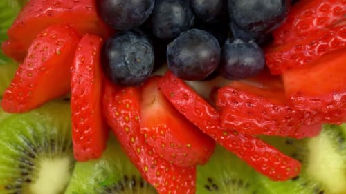 Fruit salad centerpiece. Rotating shot of a dressed plate of different fruits presented in a circula